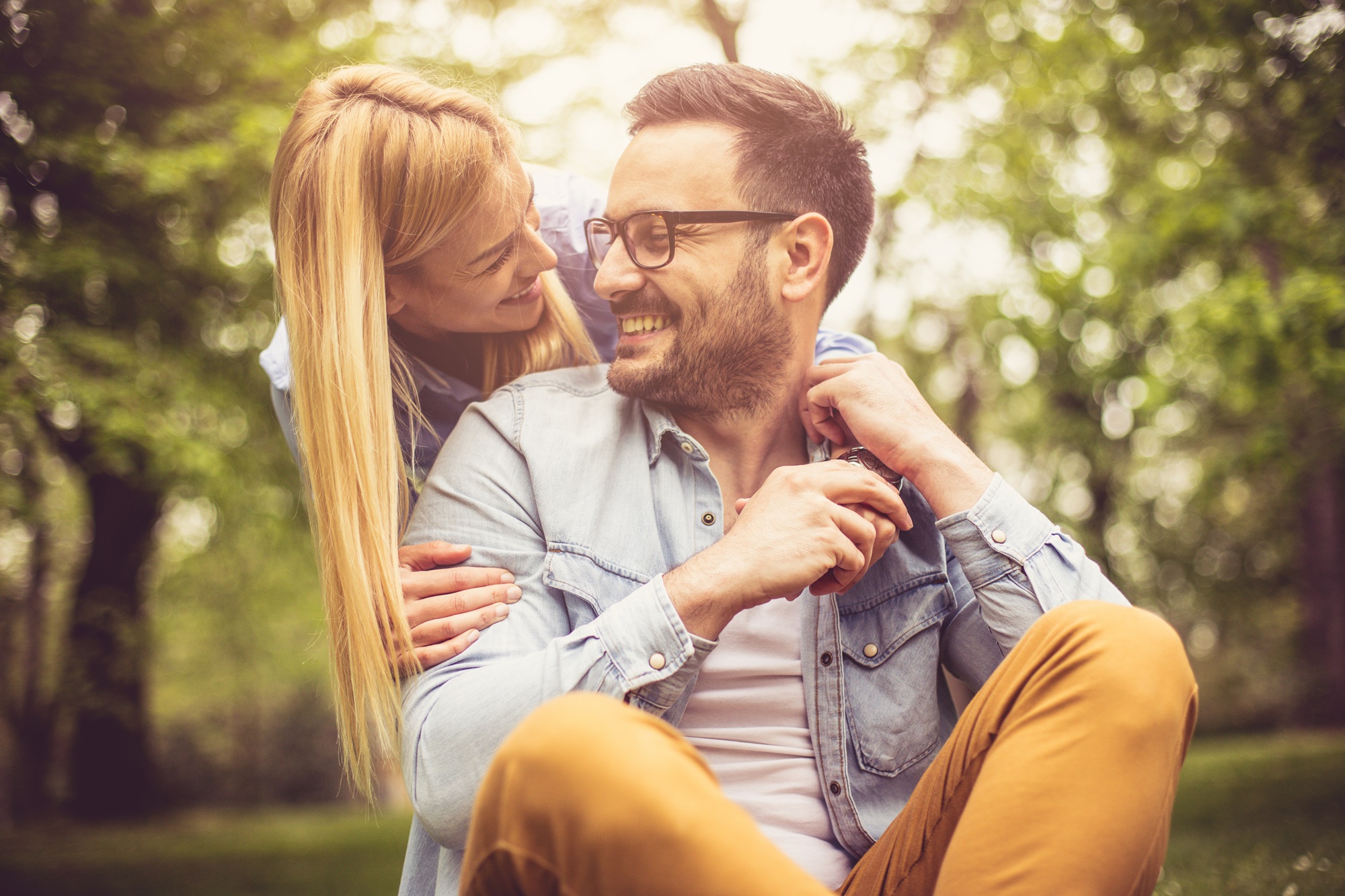 Smiling couple enjoying clear vision while wearing stylish prescription eyeglasses in a natural outdoor setting – eye doctor los angeles